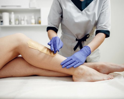 Beautiful girl doing hair removal. Woman in beauty salon